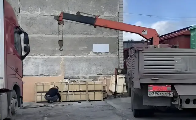 Кран-манипулятор работает с грузом на площадке