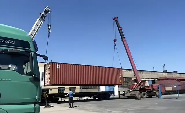 Погрузка контейнера краном на железнодорожную платформу